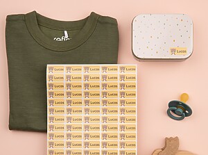 Une planche d’étiquettes autocollantes colorées avec un ours, dont une collée sur une boîte à lunch