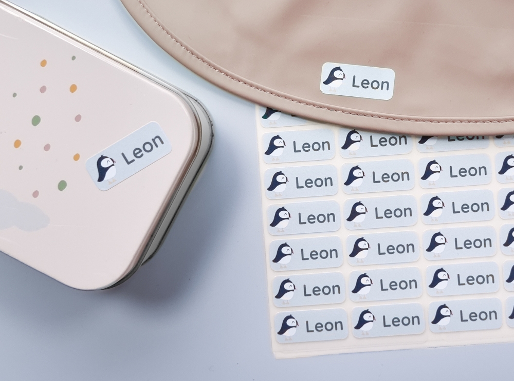 Plus de sécurité au quotidien : découvre les étiquettes nominatives pour les enfants 2 Autocollants nominatifs imperméables sur une boîte à lunch et une planche de stickers pour enfants