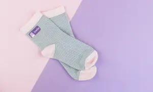 Chaussettes rayées avec étiquette thermocollante violette portant le prénom 'Stella'