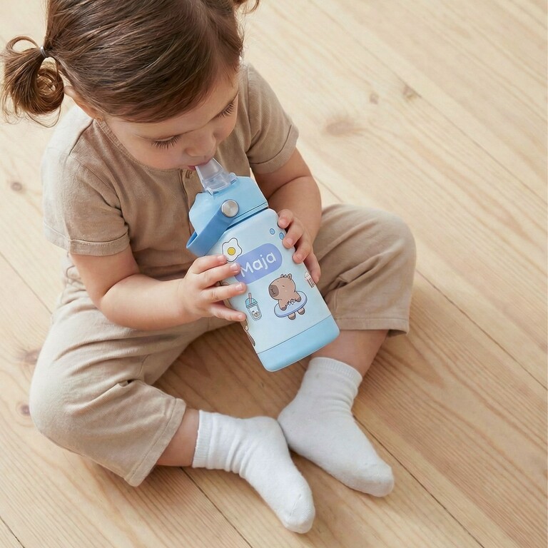 Fille buvant dans une gourde pour enfants