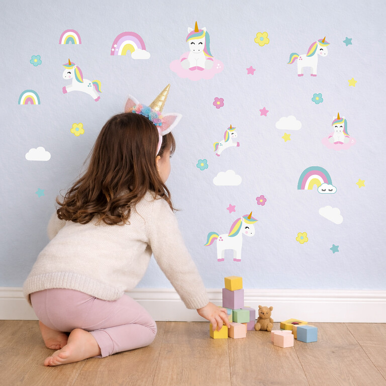 Stickers muraux licornes dans la chambre d'enfant avec un enfant qui joue