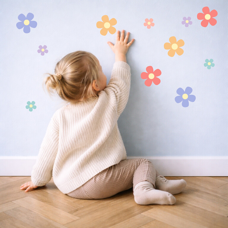 Enfant colle des stickers muraux Daisy colorés sur le mur