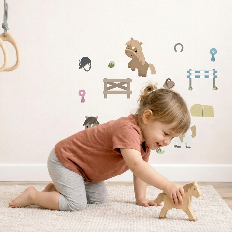 Fille collant des stickers muraux chevaux sur le mur