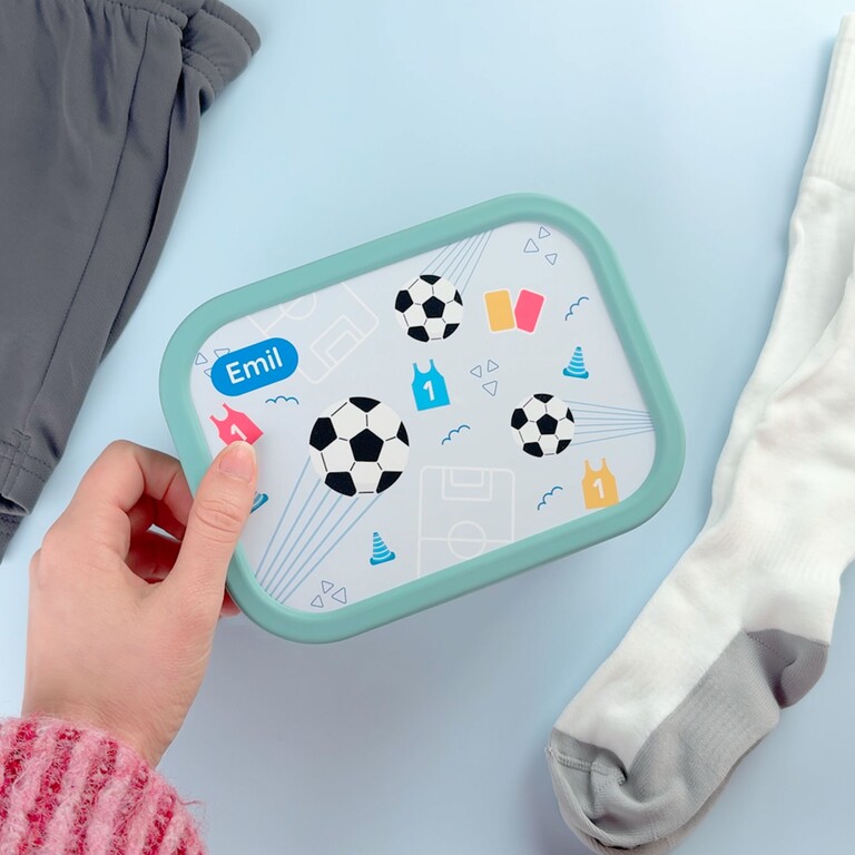 Boîte à goûter verte football tenue à la main