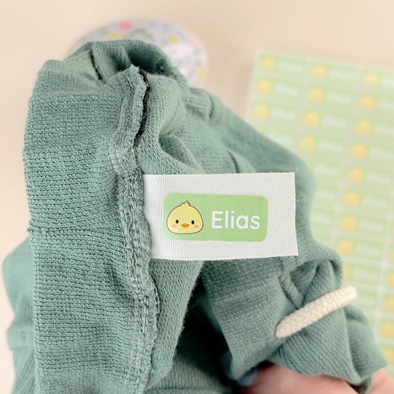Autocollants nominatifs sur un pull vert